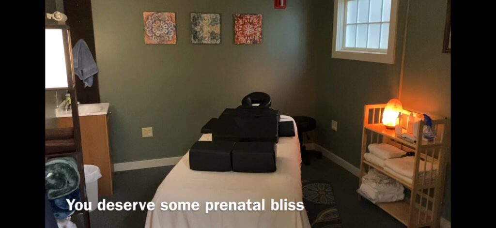 Image of a cozy massage room, with a set of pregnancy pillows set up on the table.
